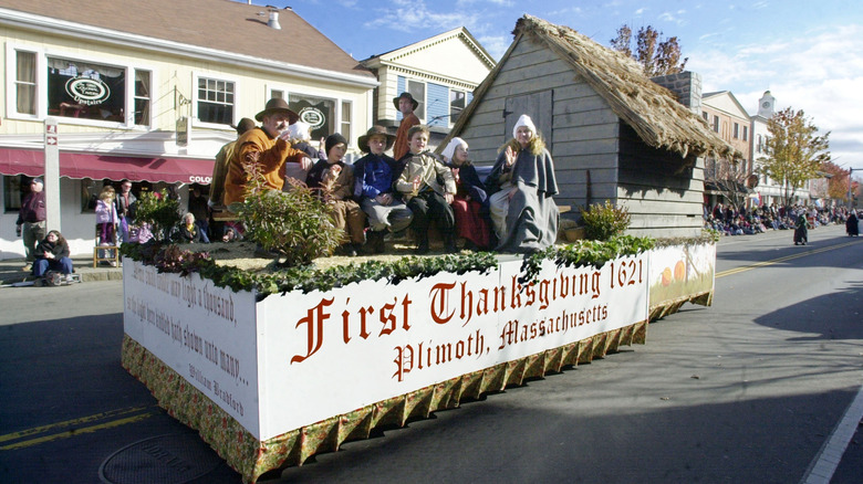 Participants in the Plymouth Thanksgiving Day Parade dressed as pilgrims on a float