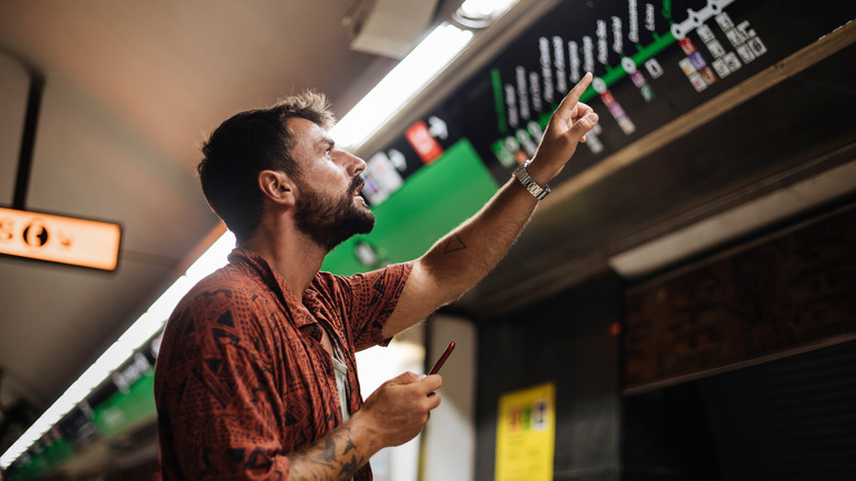 A man checking the transit map in a subway station