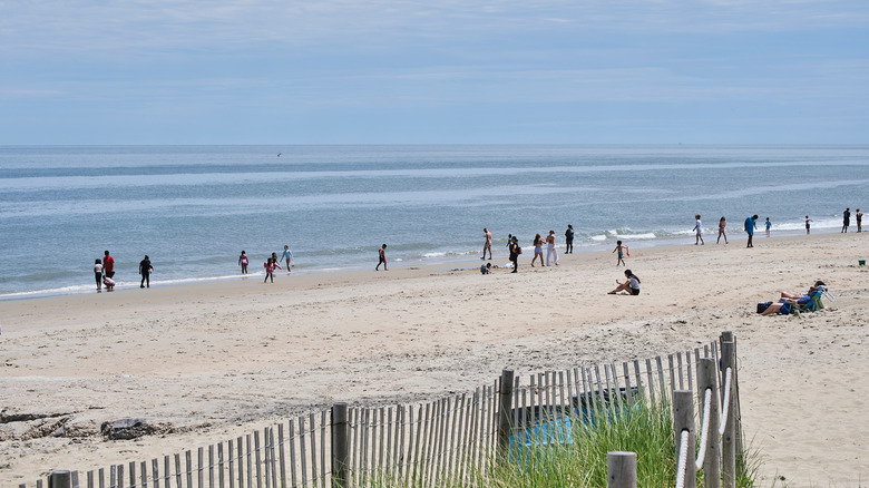 A beach without crowds, with a wooden fenced area in the foreground