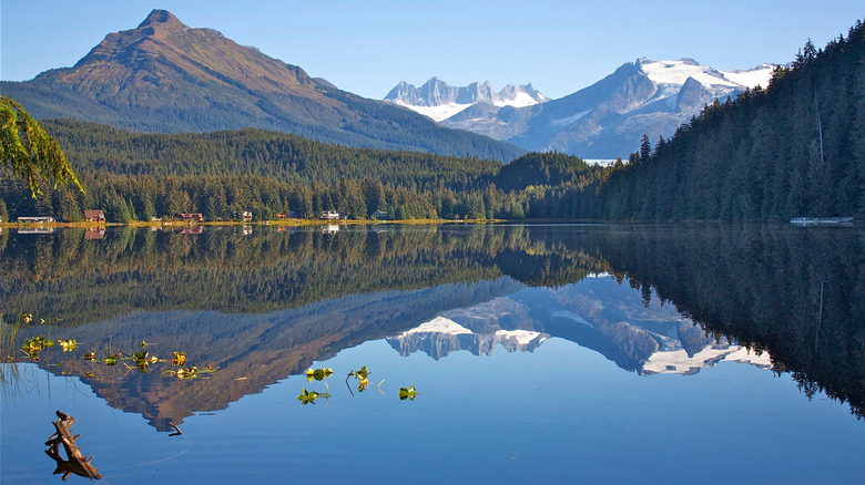 Snow-topped mountaiins loom over a lake in Alaska