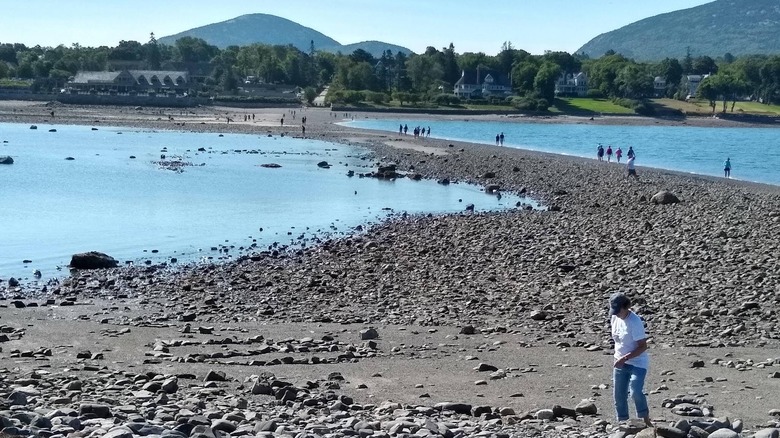 A woman crossing the land bridge at Bar Island, Maine