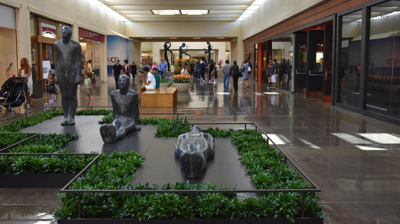 An art installation at Northpark Center with the 'Five Hammering Men' installation on view in the background