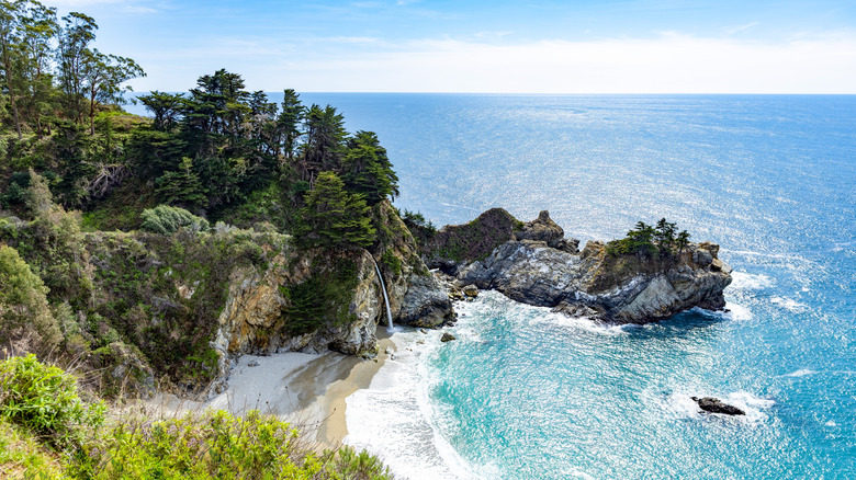 A waterfall flowing onto a beach in Big Sur, California
