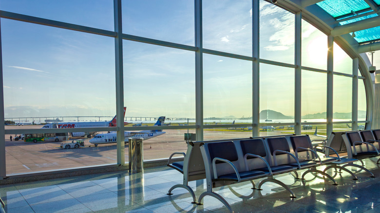 Benches in an airport gate with views of aircraft outside