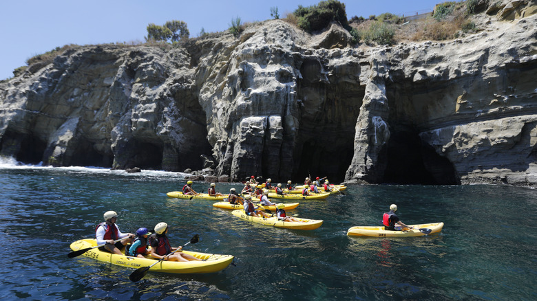 Kayakers paddling near the La Jolla Cove sea caves of the San Diego La Jolla Underwater Park Ecological Reserve