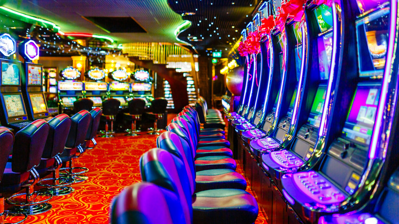 A line of brightly-lit slot machines in a casino
