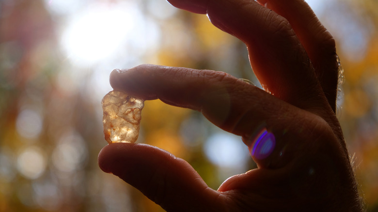 A hand holding a small semiprecious stone