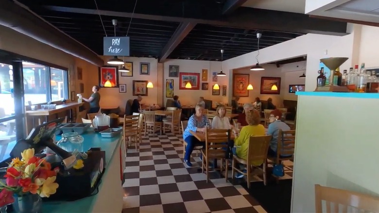 Checkered floors and wooden tables inside The Glass Onion