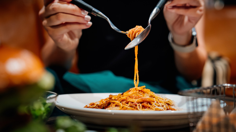 An individual eating pasta