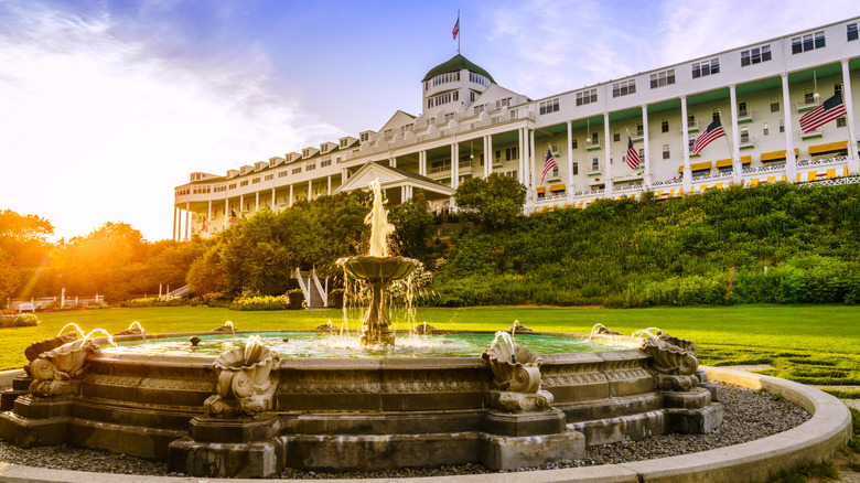 Exterior view of Grand Hotel on Mackinac Island, Michigan, U.S.A., at sunset, with its fountain in the foreground.