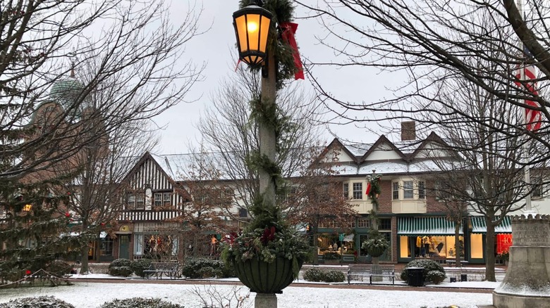 Street light with Christmas decorations in front of snow-covered brick buildings Market Square Illinois