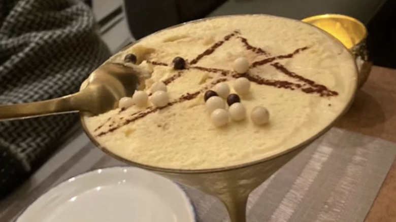 Close-up view of espresso martini at La Stella Cucina Verace, with star and edible pearls on the foam with dim evening lighting