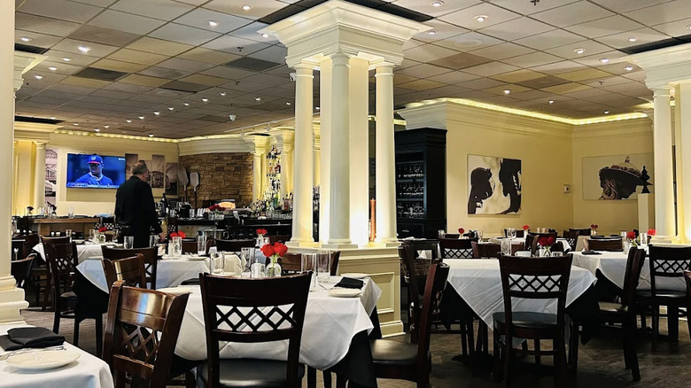 Interior view of Luciano's Ristorante Italiano in Duluth, Georgia, with white crown molding and white, Roman-inspired columns amid dark wood tables with white tablecloths