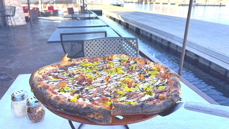 Plate of pizza on table next to water at Arizona's floating restaurant
