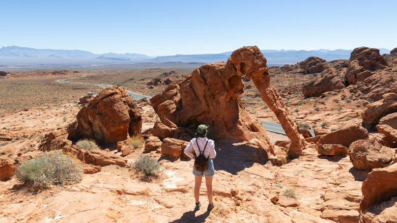 A woman stands in front of a rock at Valley of Fire State Park