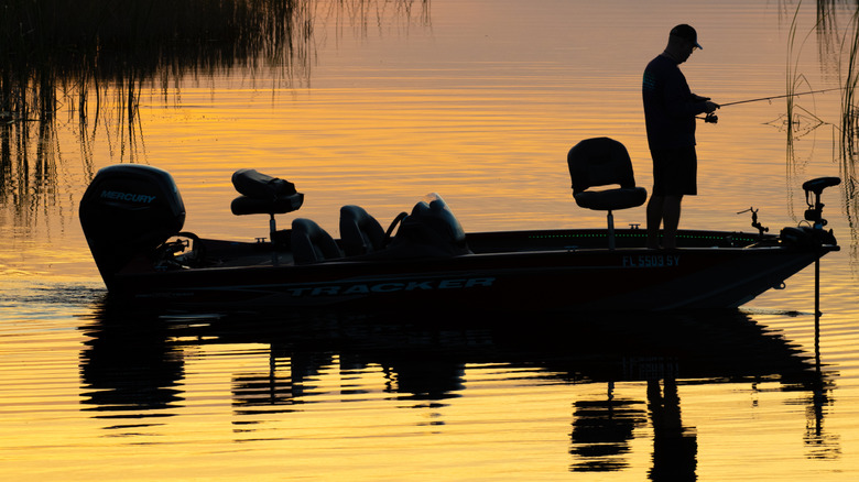 Silhouette of man fishing off of his boat in the Everglades.