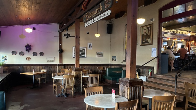 An interior view of Scholz Garten, showing chairs and tables with historic photos on the walls.