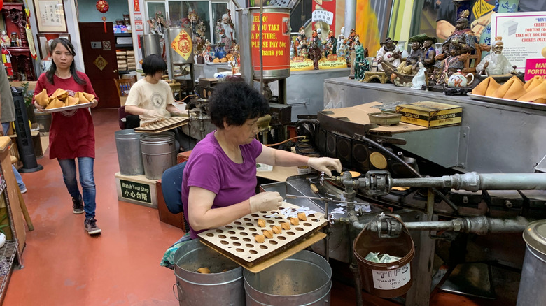 Woman working at the Golden Gate Fortune Cookie Factory tucked in one of the alleys of Chinatown in San Francisco
