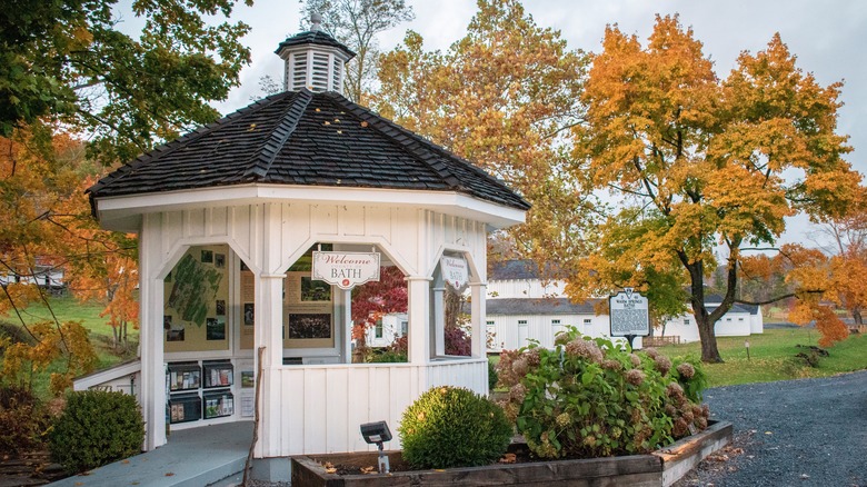A white gazebo with a welcome sign to Warm Springs Pools
