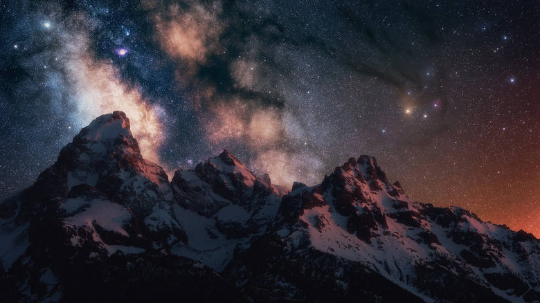 The Milky Way glitters above snow-capped peaks in the Grand Tetons, Wyoming