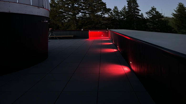 Part of the Snow King Observatory dome stands next to evergreens at dusk