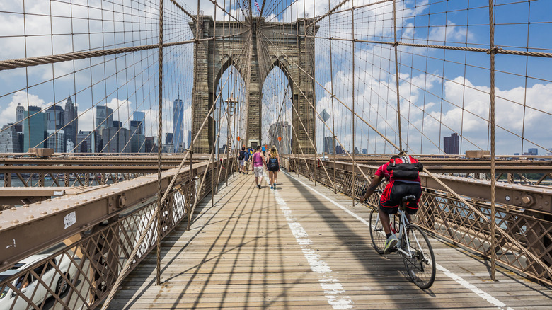 A cyclist and pedestrians on the Brooklyn Bridge in NYC