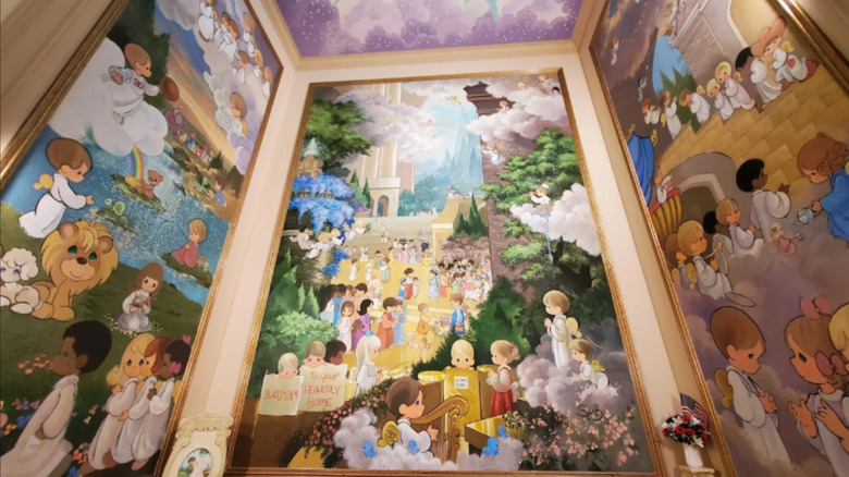 Interior of the Precious Moments Chapel in Carthage, Missouri with colorful biblical murals lining the walls and ceiling