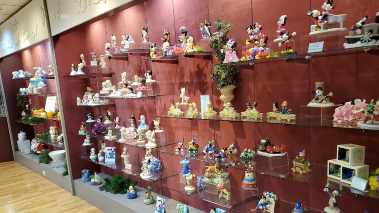 Shelves displaying Precious Moments figurines, some with Disney characters, in the gift shop