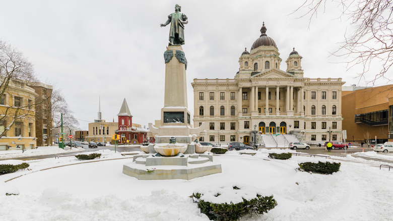 Historic square in Syracuse covered in snow with a regal building and statue