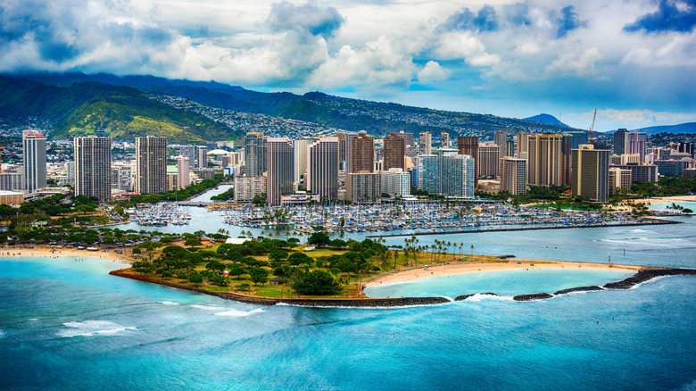 Buildings along coastline with mountains behind them in Honolulu