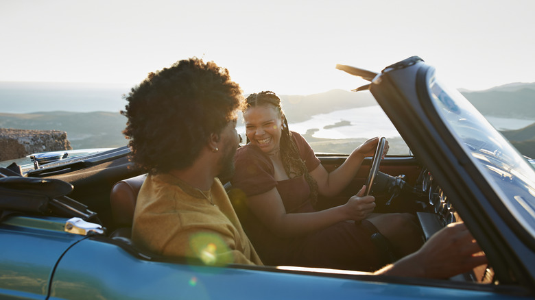 A couple driving in a convertible