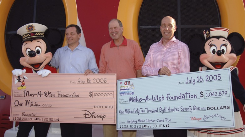 Disney mice holding Make-A-Wish chekcs