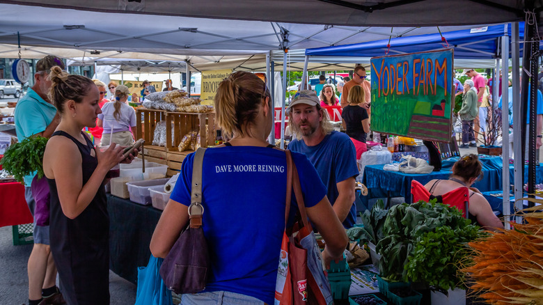 Shoppers at a fresh fruit and vegetable market stall in Palisade, Colorado