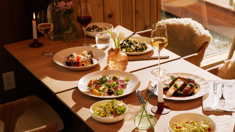 Multiple food dishes and wine on a table in The Cliff House restaurant