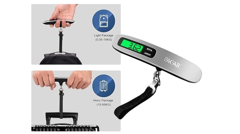 A hand weighs a suitcase with a small, silver digital luggage scale with a strap and hook.
