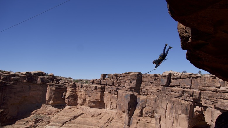 A person experiencing the rope swing at Moab