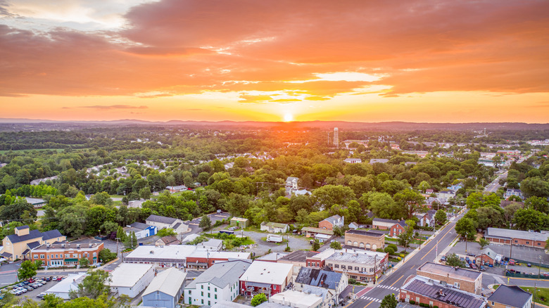 The sunrise over Purcellville, Virginia, with homes, businesses, and lush trees dotting the town