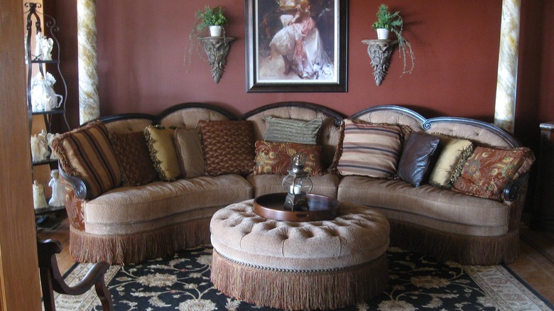 A tasselled footrest and sofa with cushions in the common area of The Lady on the Lake Bed and Breakfast