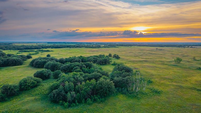 An expansive aerial view of North Dakota's Sheyenne National Grassland under a striking sunset