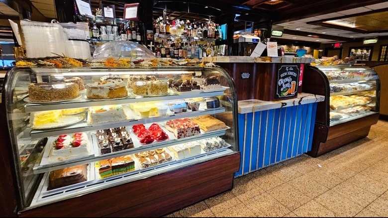 Interior of State Line Diner in Mahwah, New Jersey, featuring a pie case with wooden finishes in front of a bar