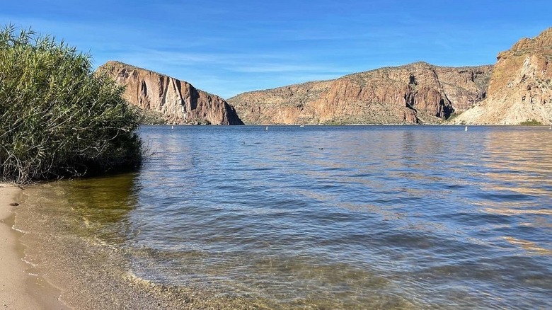 View of the lake shore with cliffs in the distance