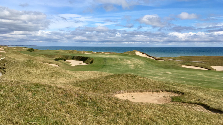 The rolling fairway of Whistling Straits with sand bunkers and Lake Michigan on the horizon