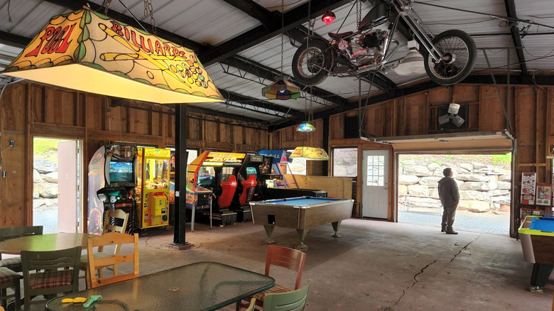Game room at Cranberry Run Campground, with a billiards table, old arcade games, and a person standing by the door