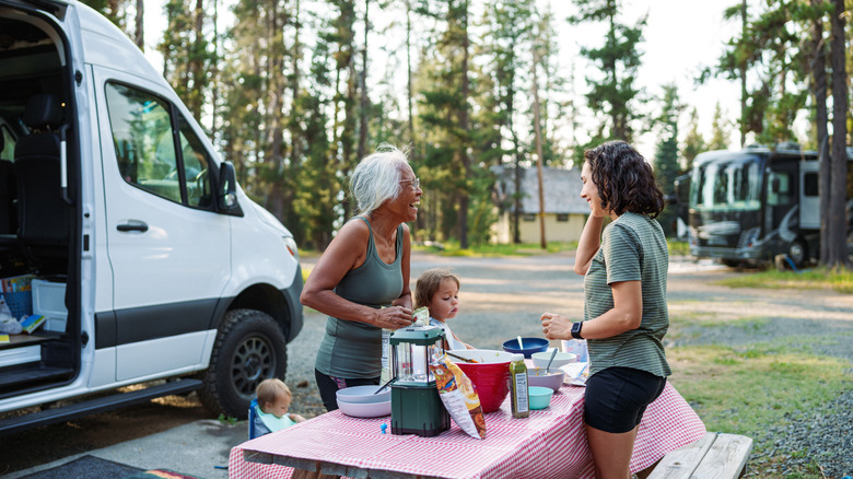Family talking by a picnic table at an RV park