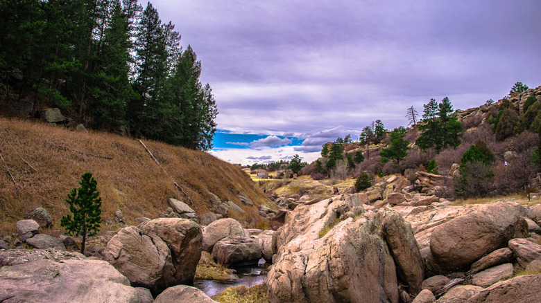 Boulders in creek with purple sky