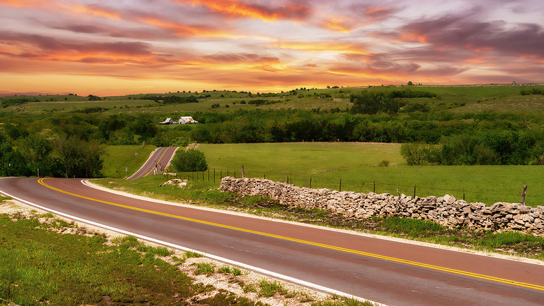 Road in the rolling green hills at sunset in the Flint Hills
