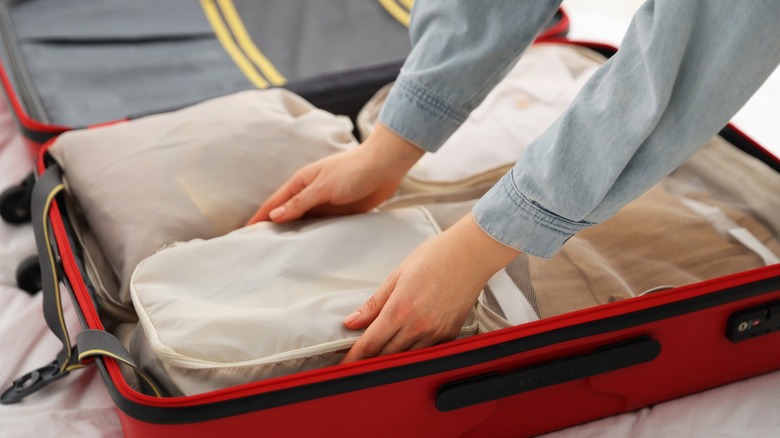 Traveler preparing a suitcase with packing cubes