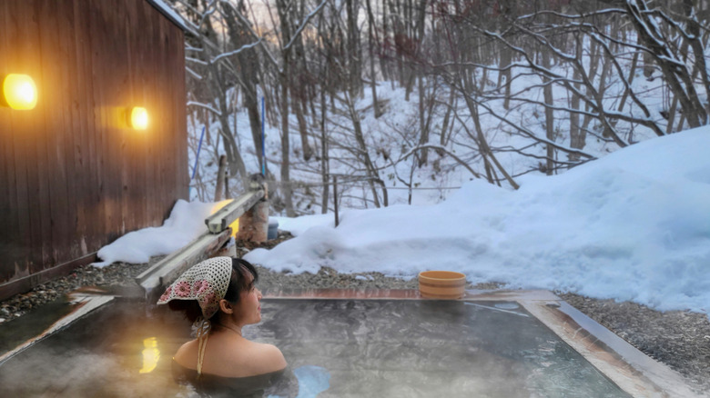 A person in a bathing suit in a hot spring.