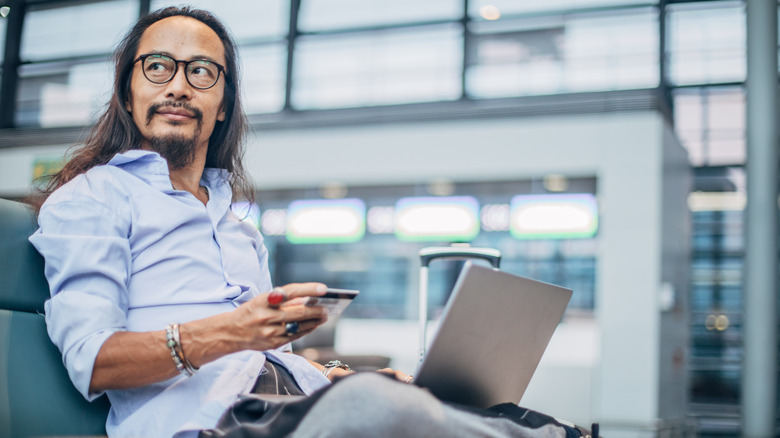 Traveler using airline credit card at airport