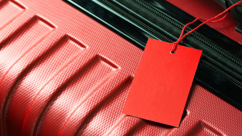 Red hardshell suitcase and tag